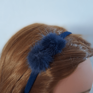 kinderhaarband met pluizenbolletje in het haar blauw